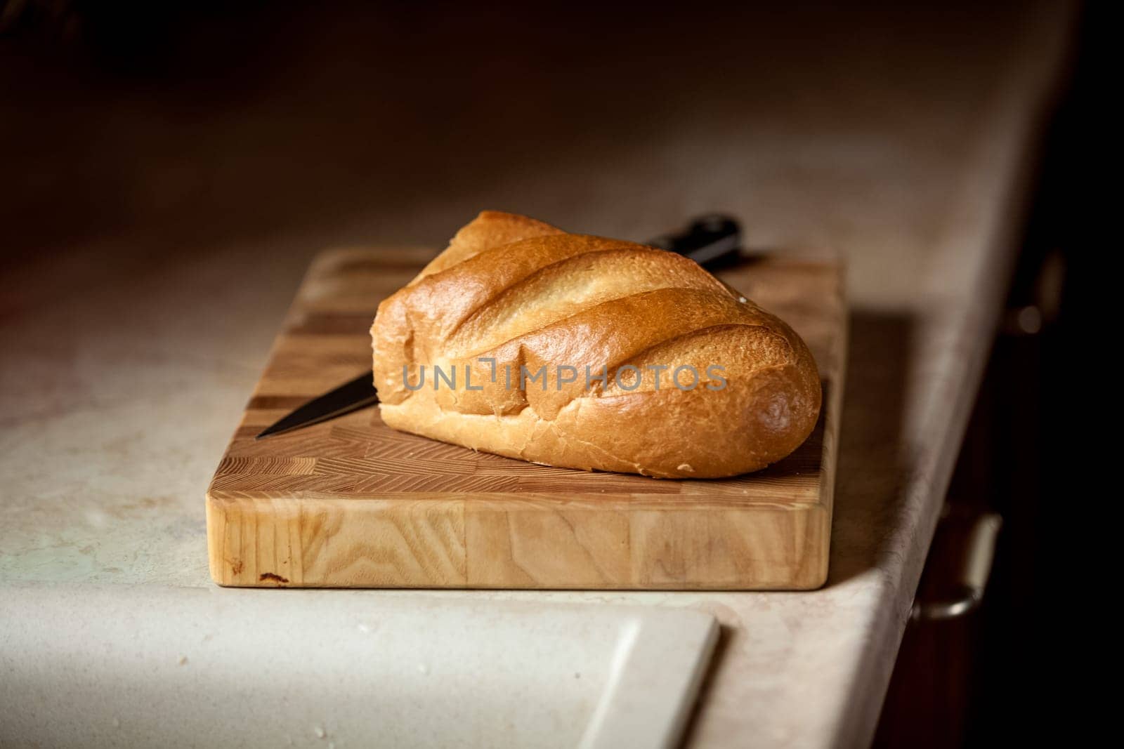 Closeup photo of bread and knife on wooden desk