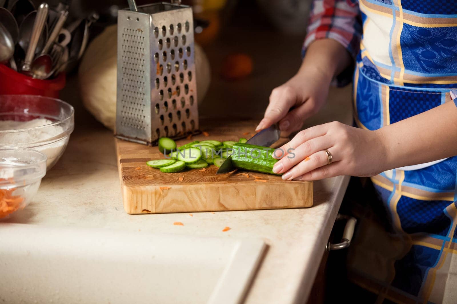 Closeup photo of woman cutting cucumber on wooden board