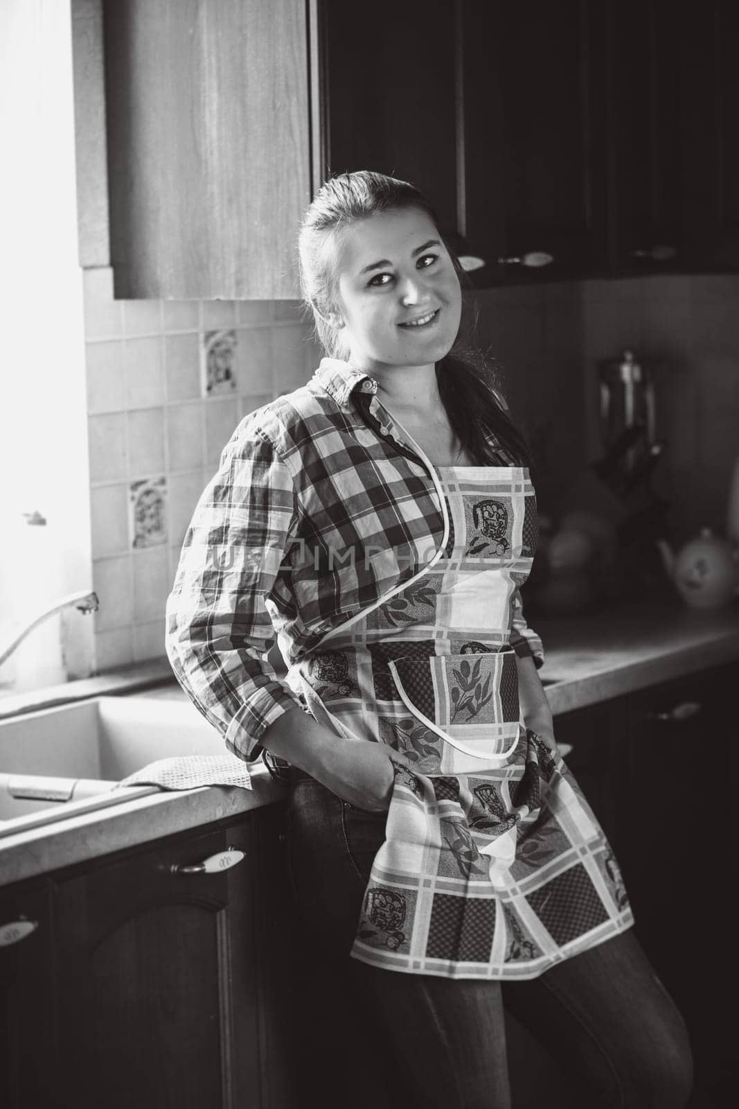 Black and white portrait of smiling housewife in apron