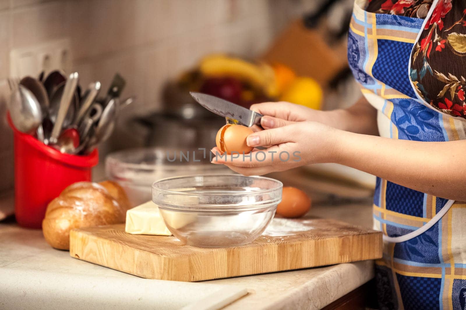 Closeup photo of housewife cracking egg with knife