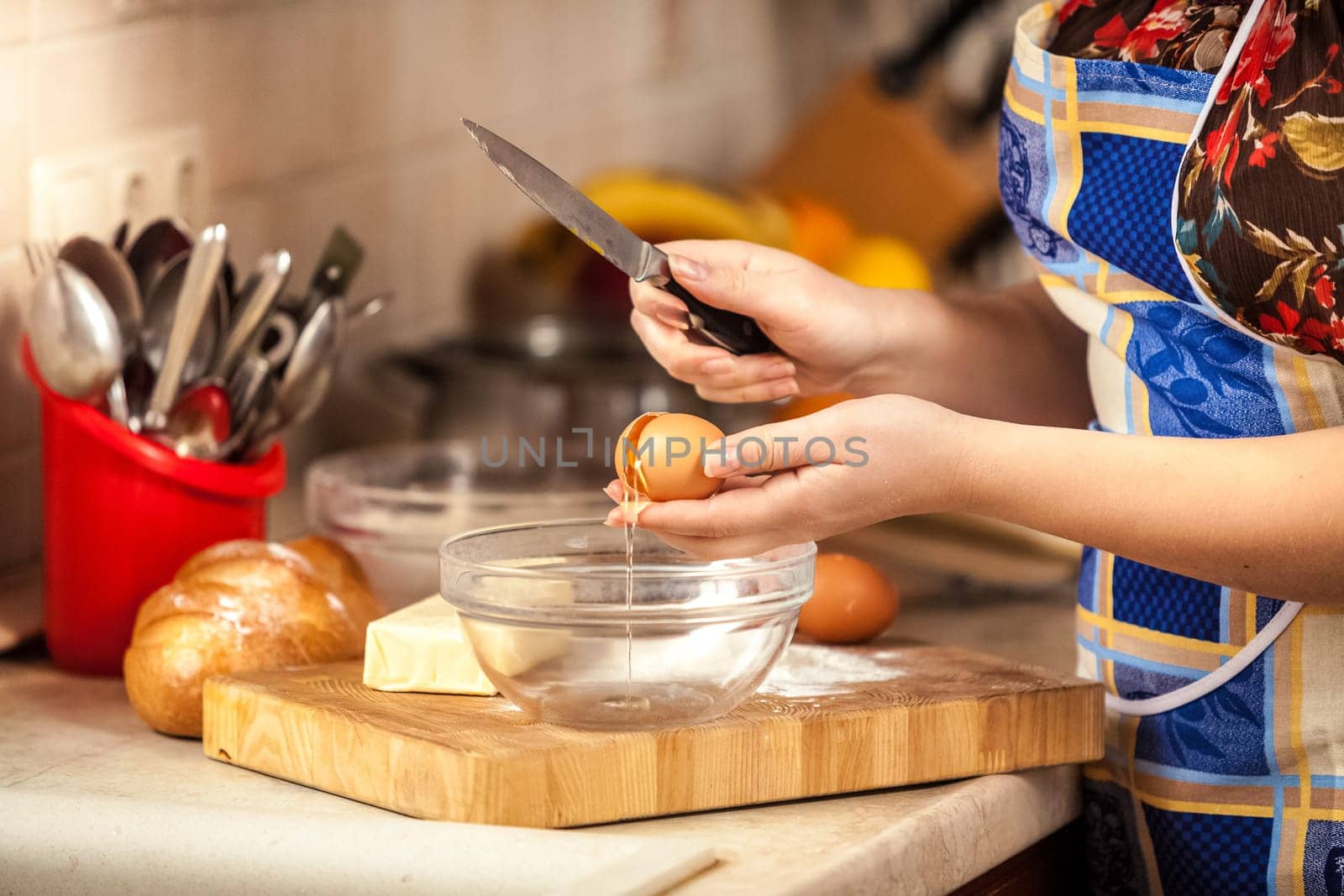 Closeup photo of woman cracking egg with knife