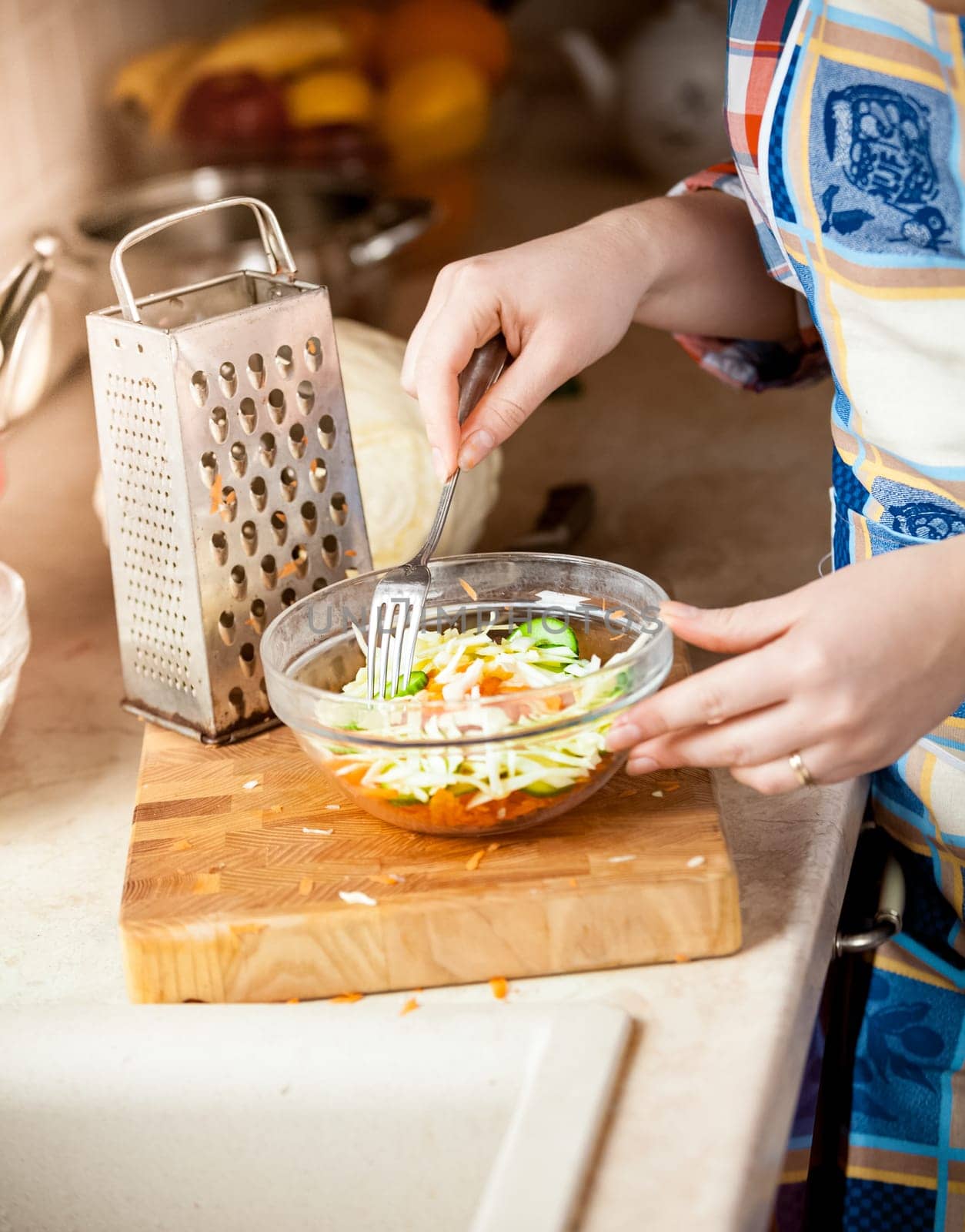 Closeup photo of housewife woman mixing salad with fork