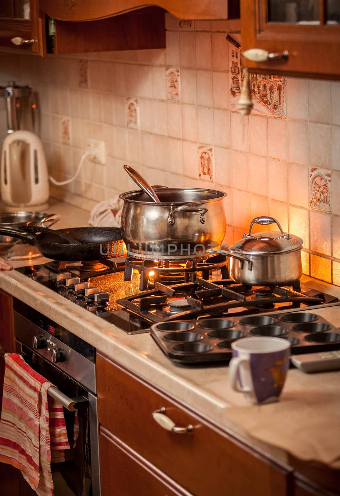 Closeup photo of metal pan boiling on burning gas stove on country style kitchen