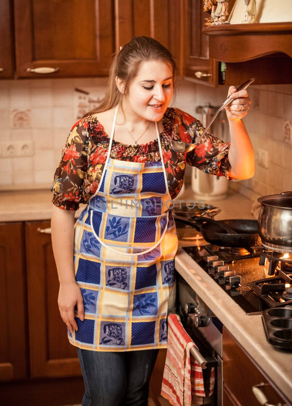 Closeup portrait of woman trying soup with ladle