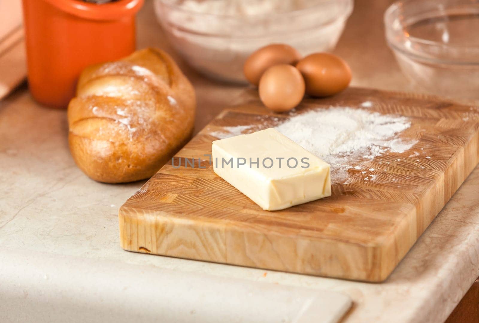 Closeup photo of butter, eggs, and flour lying on wooden board