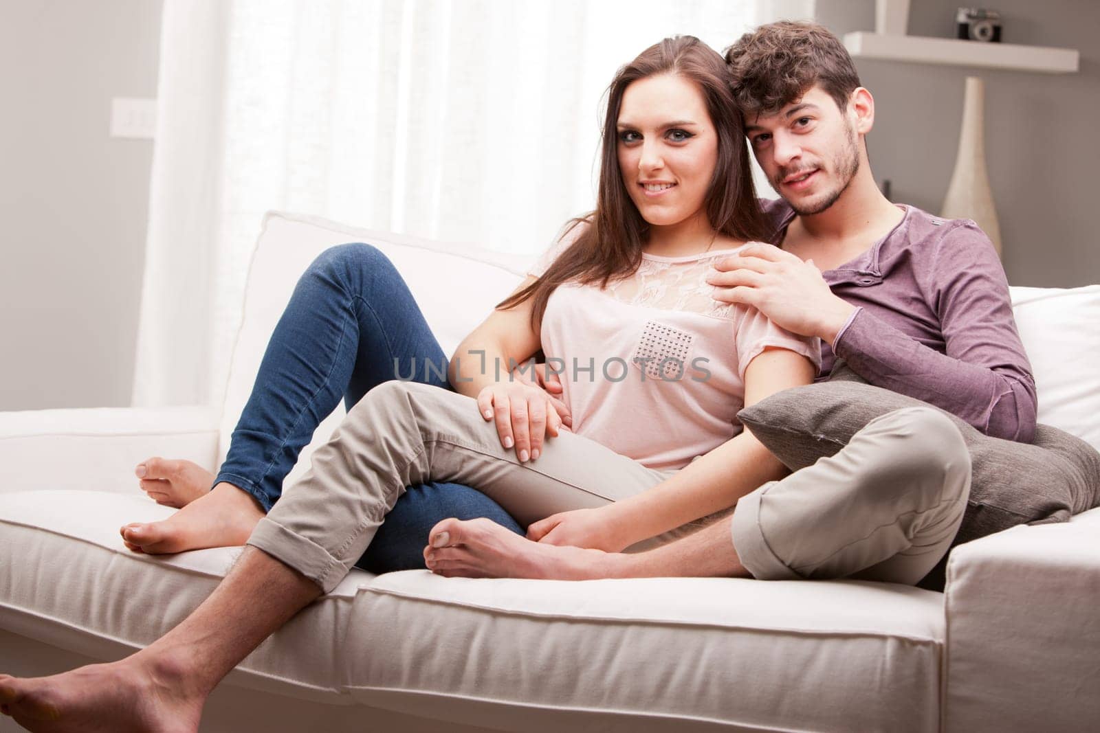 couple of lovers in relax glaze on a sofa in a well lit living room