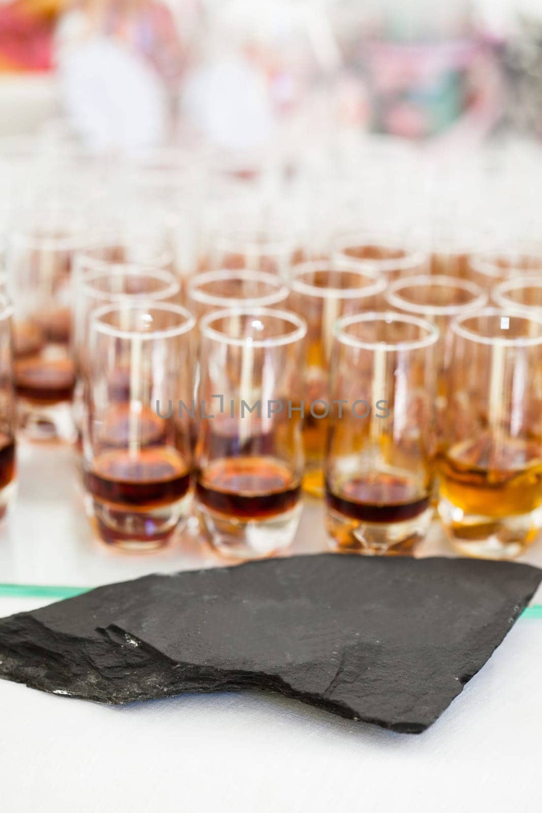 Closeup of glasses of fruity flavoured apertifs behind decorative stone