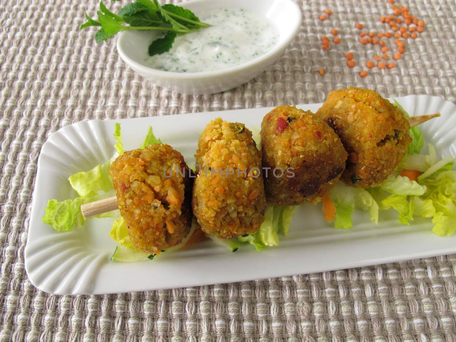 Red lentils balls on skewer with dip