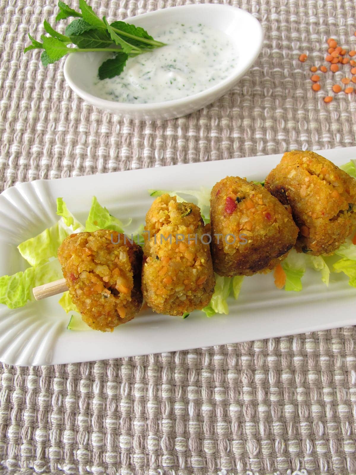Red lentils balls on skewer with dip