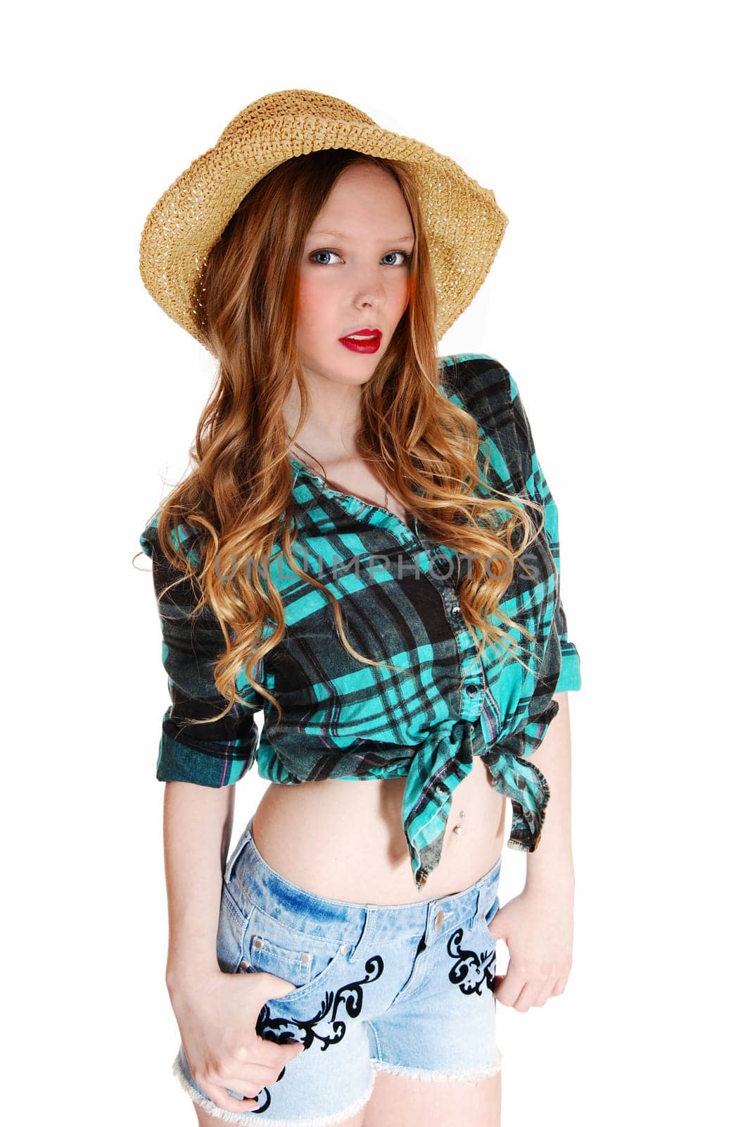 A lovely young teen girl in shorts and blouse with a straw hat standing.isolated for white background..
