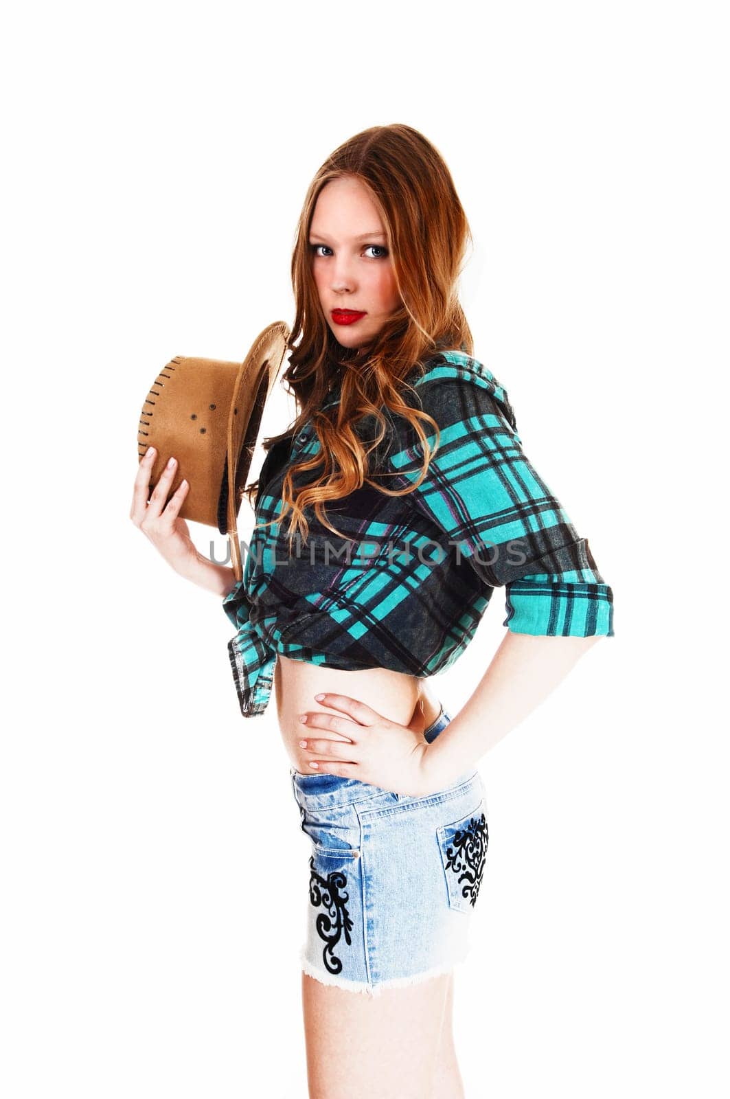 A lovely young teen girl in shorts and blouse holding a straw hat standing.isolated for white background..
