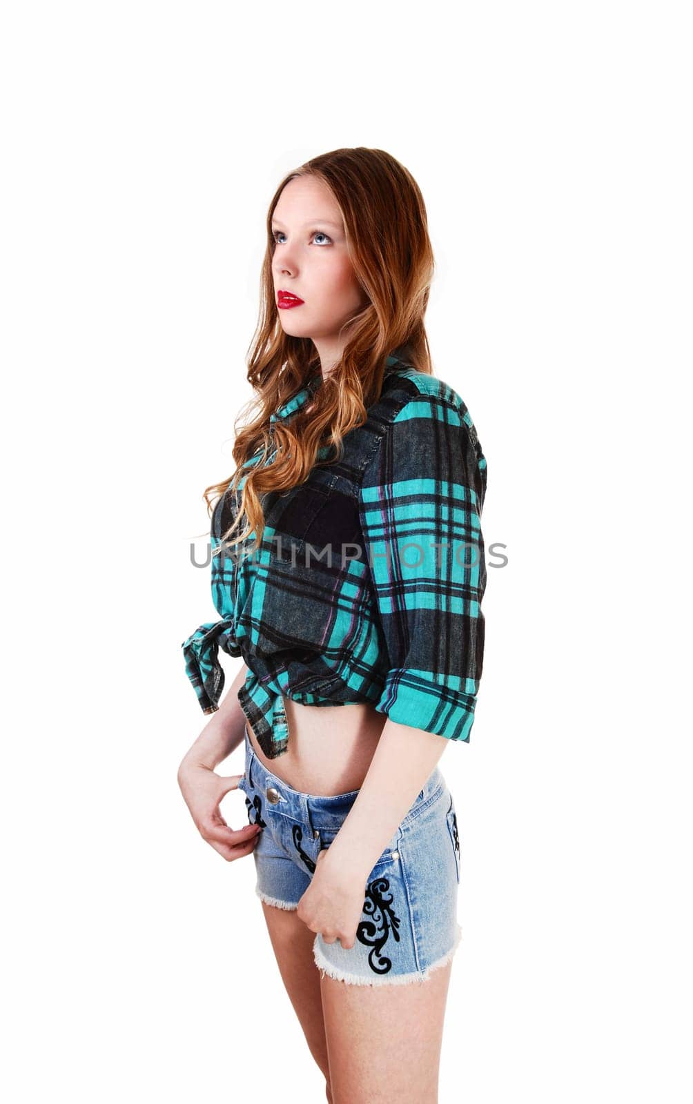 A lovely young teen girl in shorts and blouse, looking up, standing.isolated for white background..