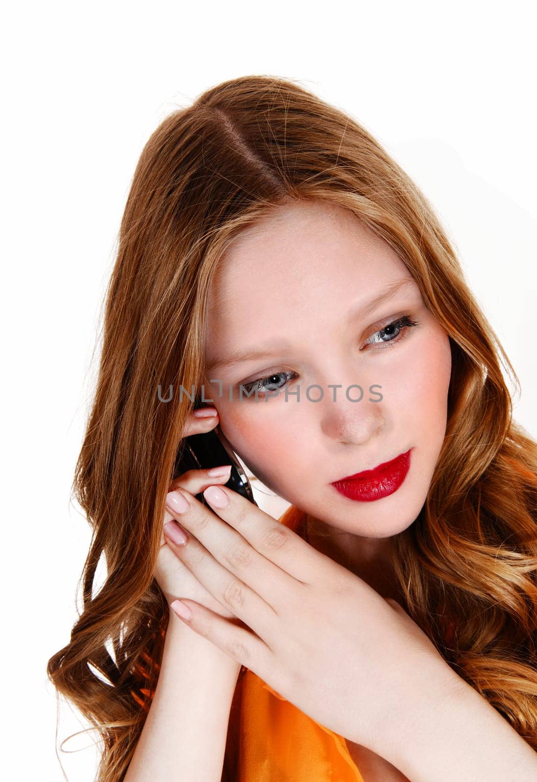 A beautiful teenager girl holding a cell phone on her ear, with long.blond hair, isolated for white background..