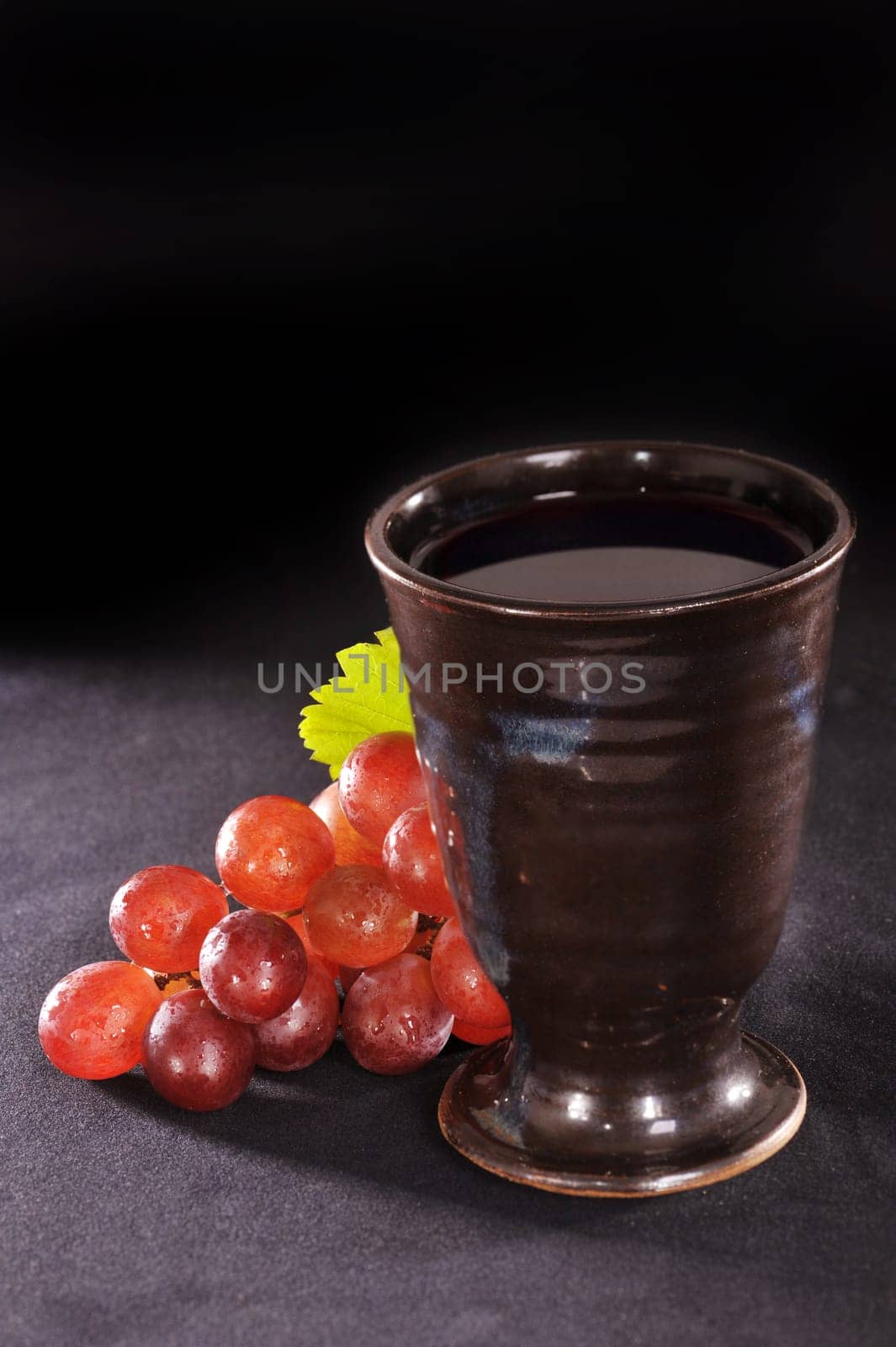 Grapes and goblet on a black background