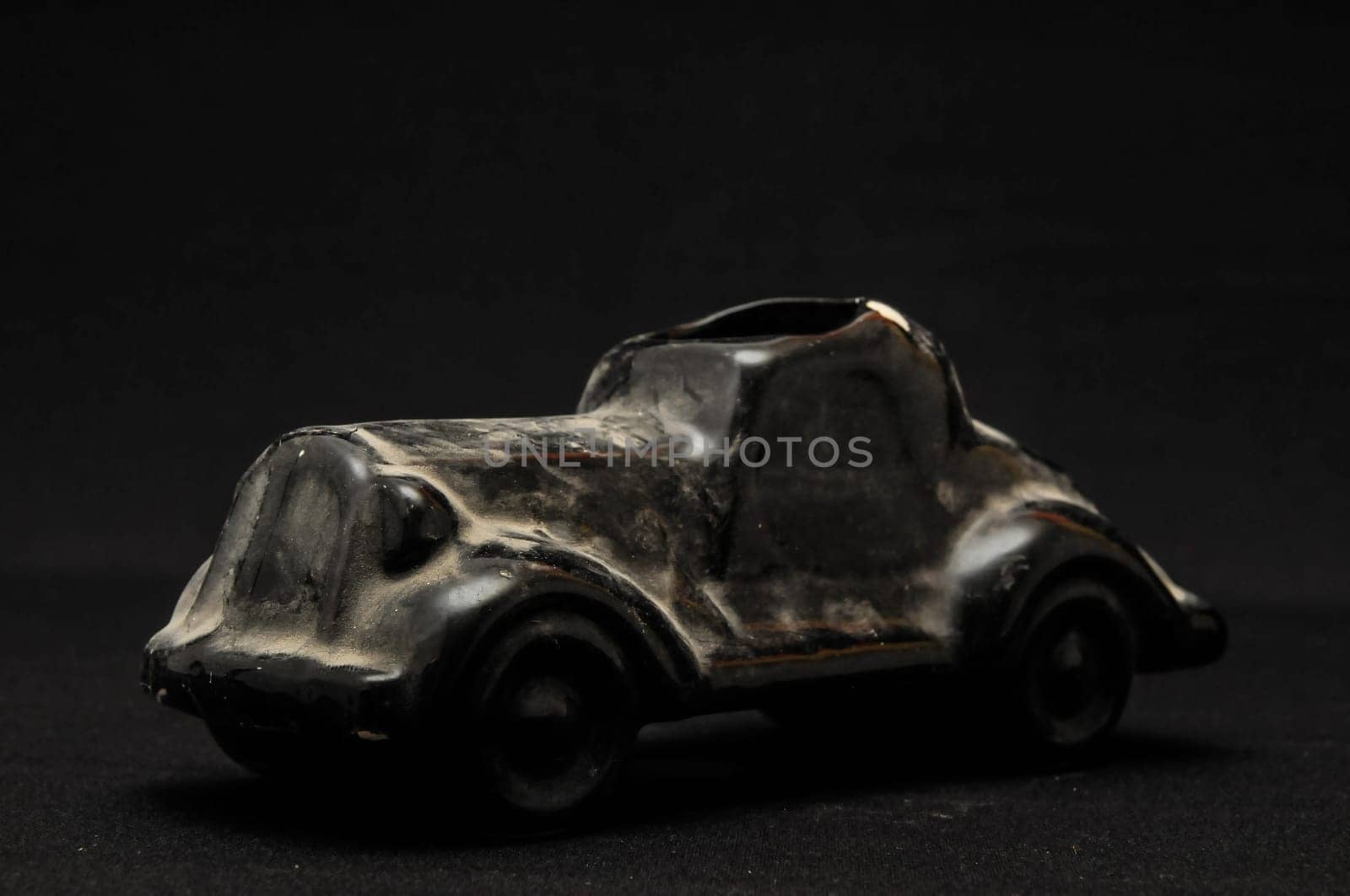 Vintage Old Ceramic Black Car on the Dark background