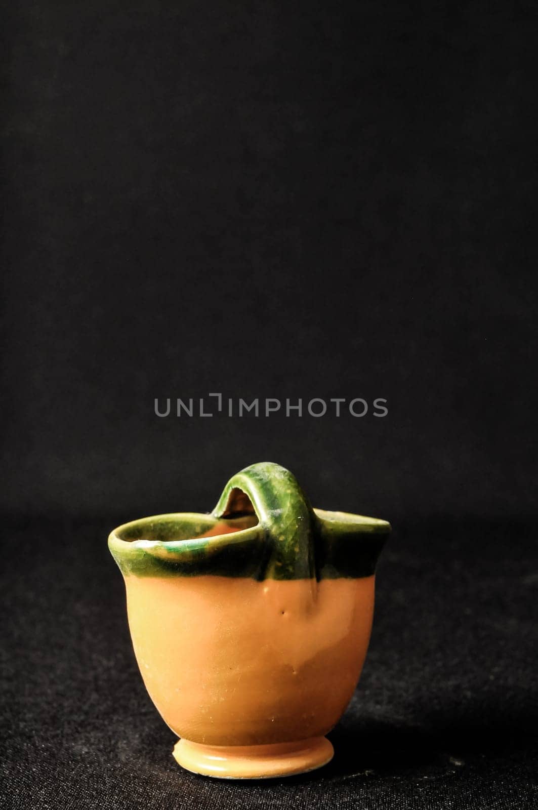 Colorful designed clay vase over a Black background