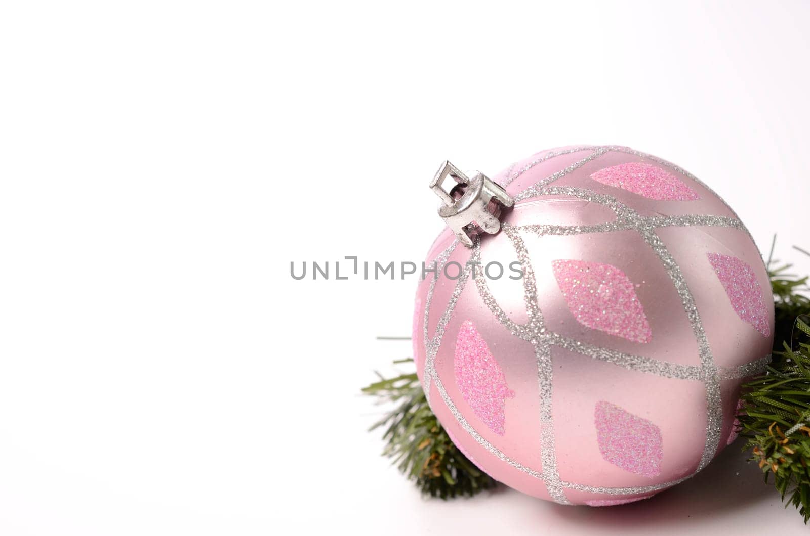Pink Christmas bauble with a green twig