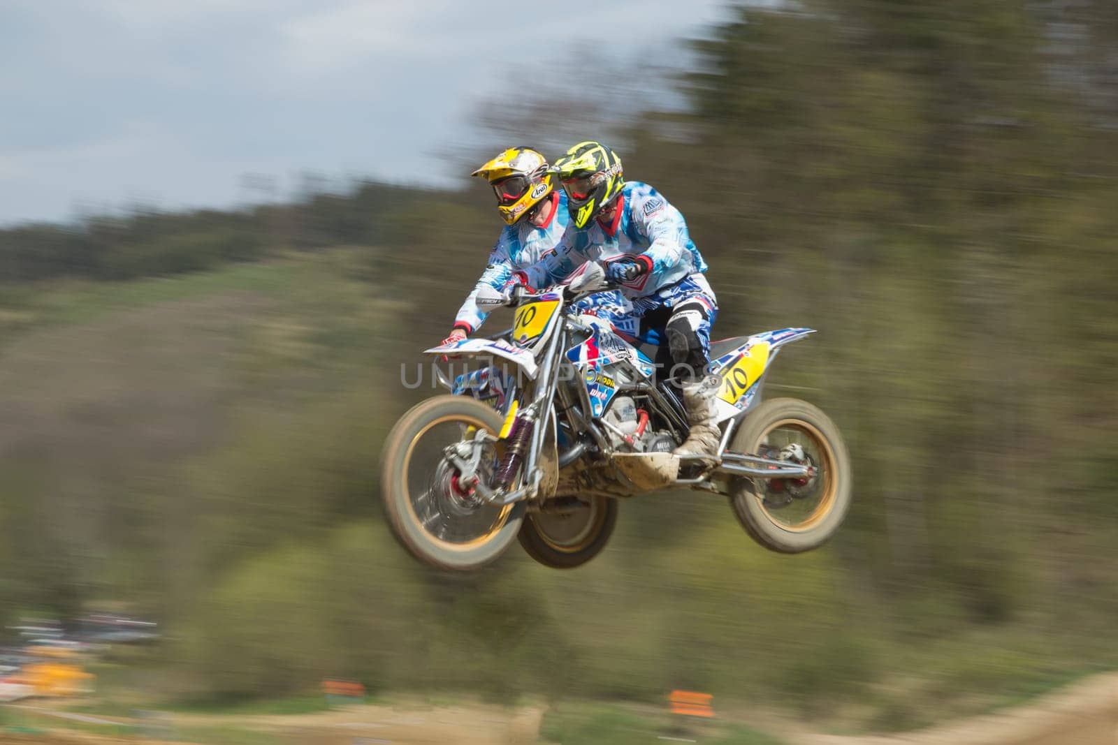 MOHELNICE, CZECH REPUBLIC - APRIL 19. Two racers in blue are jumping a sidecar in the "International Championship of Czech Republic 2014"" on April 19. 2014  in the town of Mohelnice, Czech Republic."