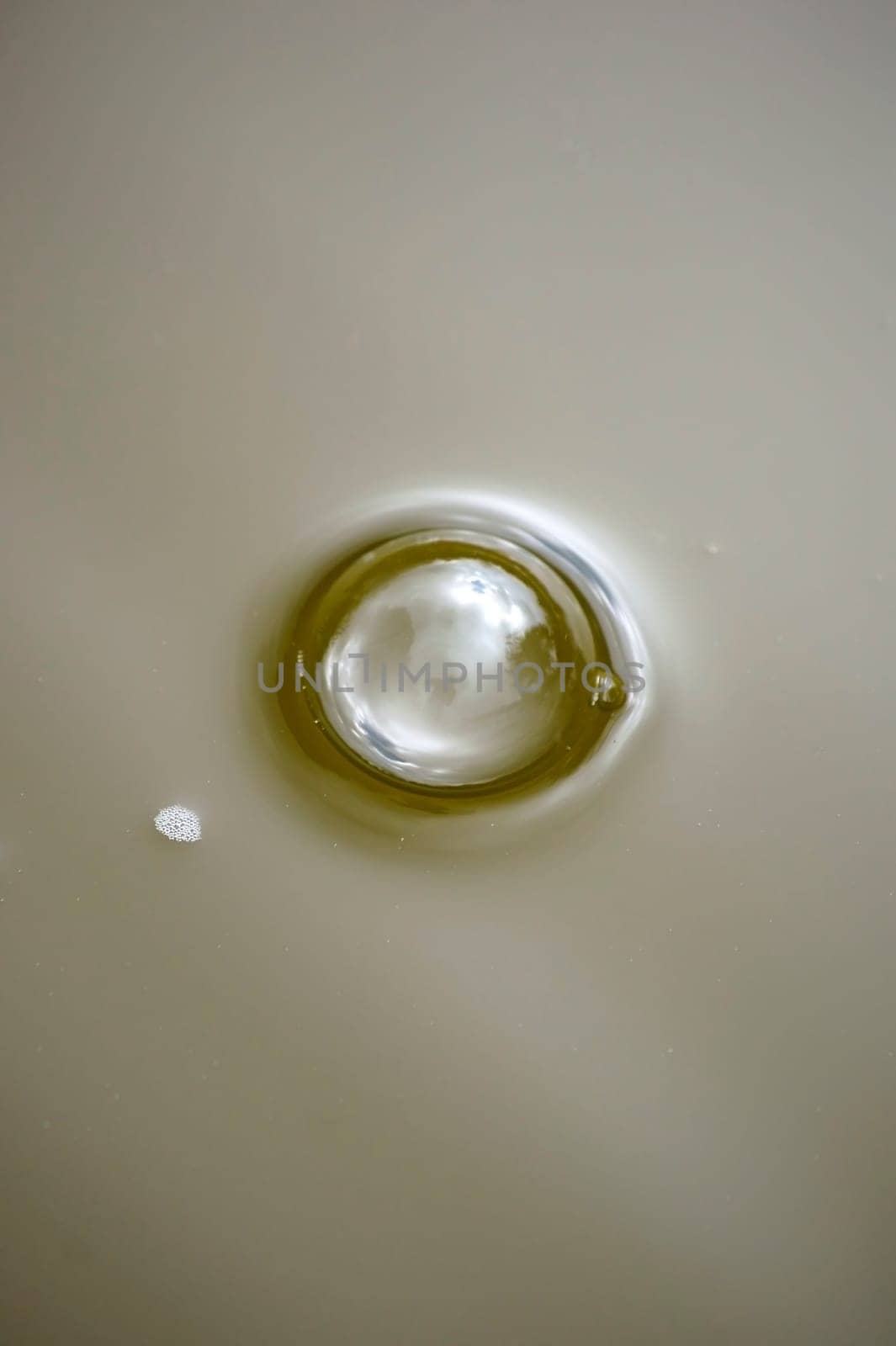 The close-up of an air bubble with reflections on the water