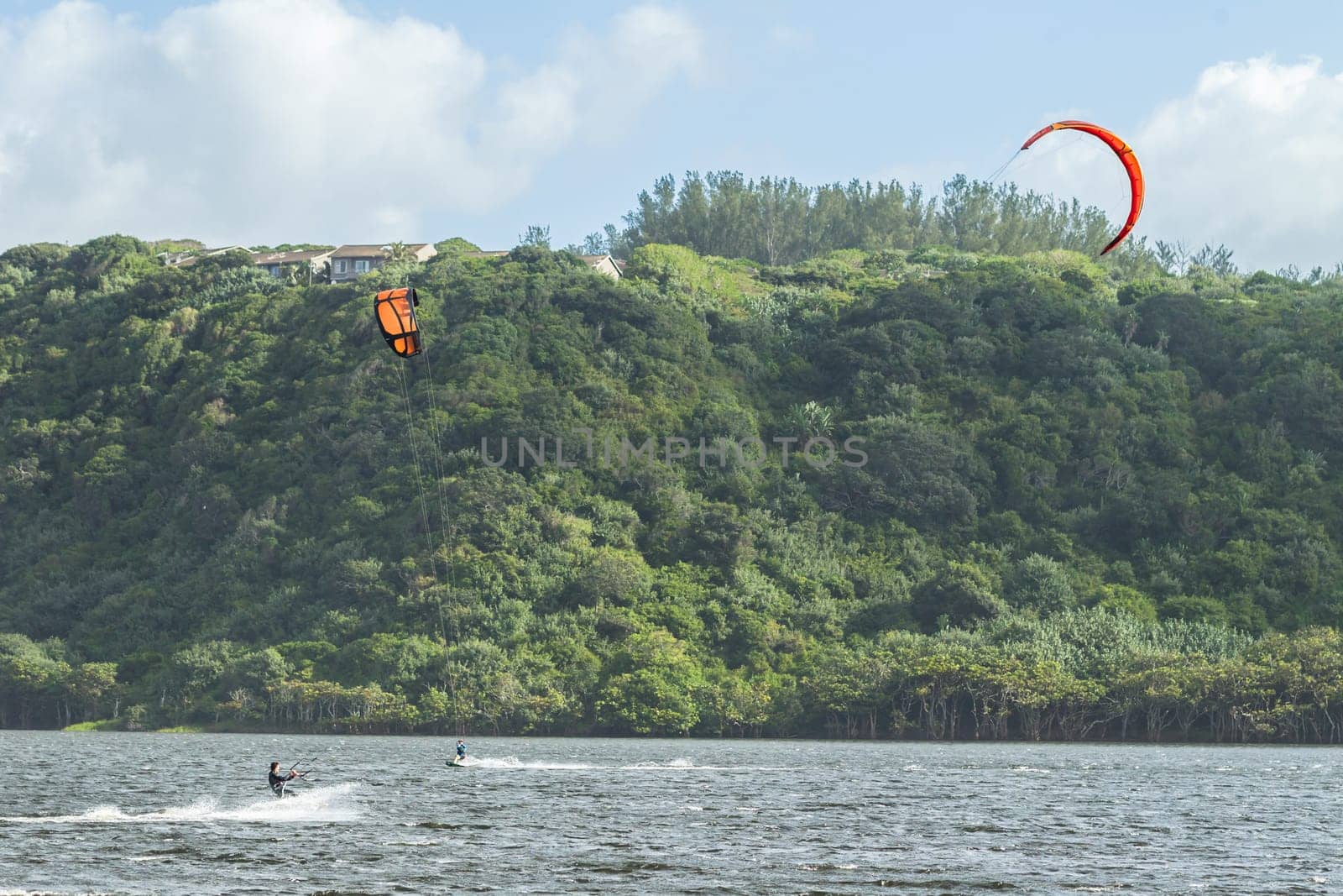 Kite surfing sport action in river lagoon waters and surf action Umdloti river lagoon north of Durban South Africa.