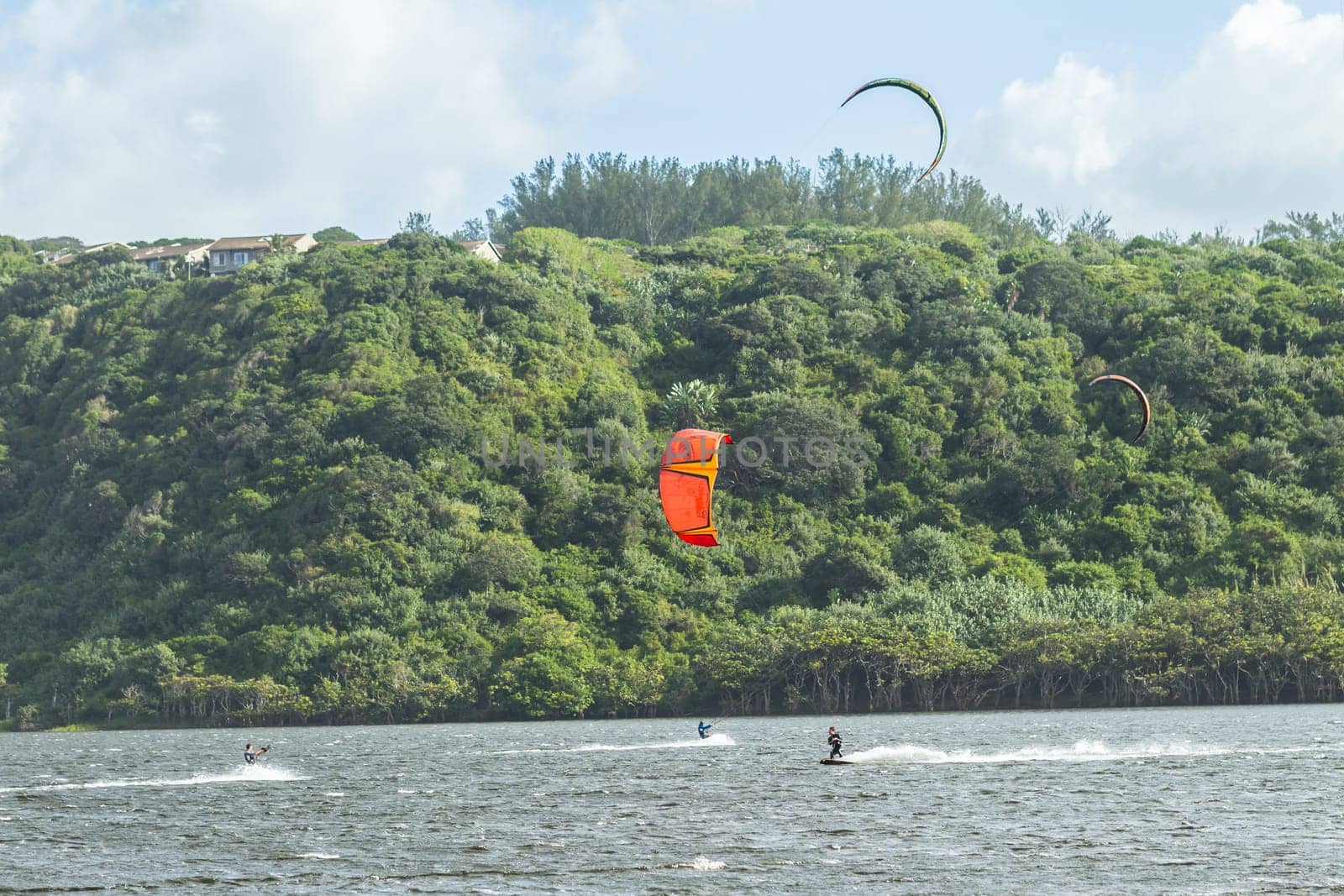 Kite surfing sport action in river lagoon waters and surf action Umdloti river lagoon north of Durban South Africa.