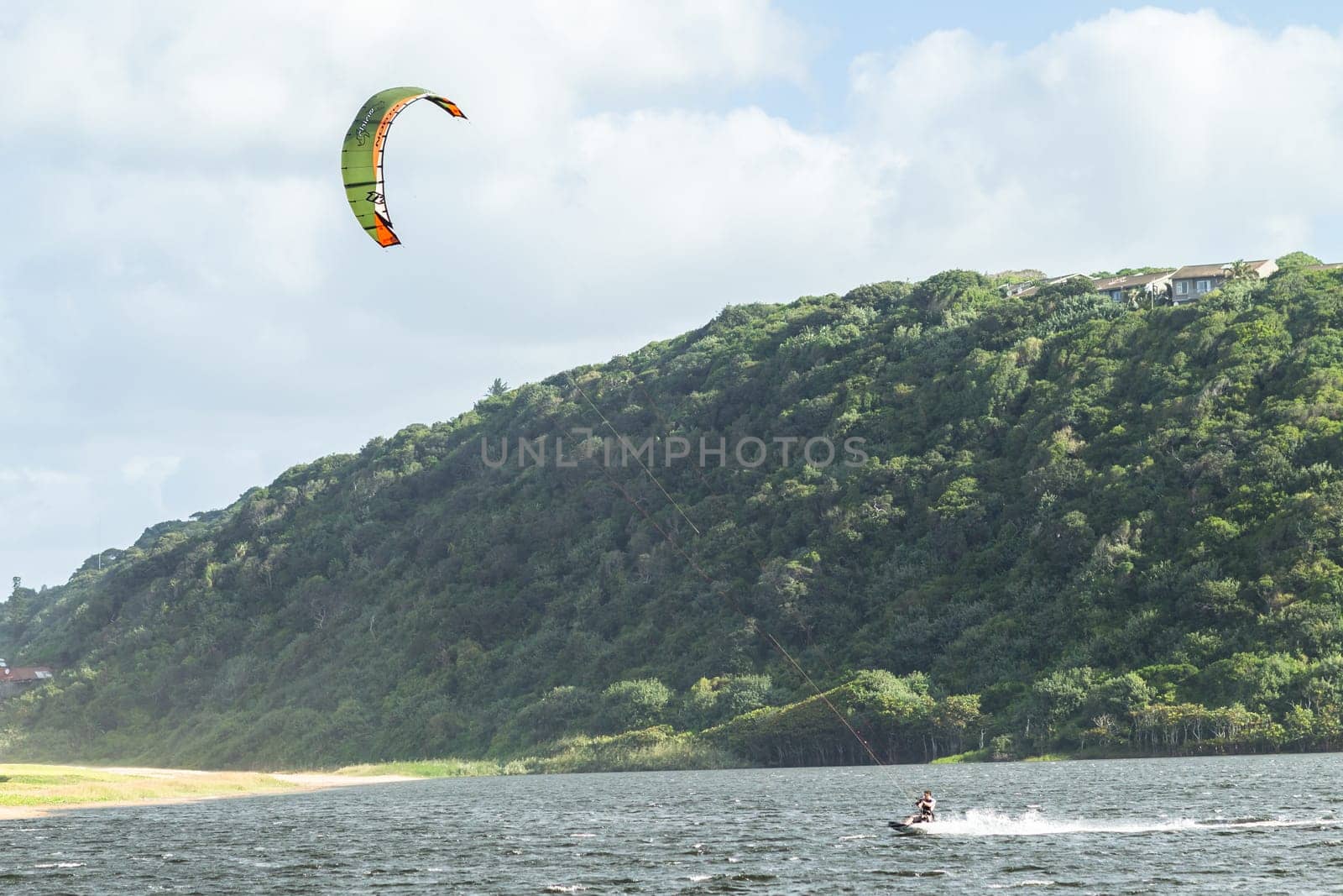 Kite surfing sport action in river lagoon waters and surf action Umdloti river lagoon north of Durban South Africa.