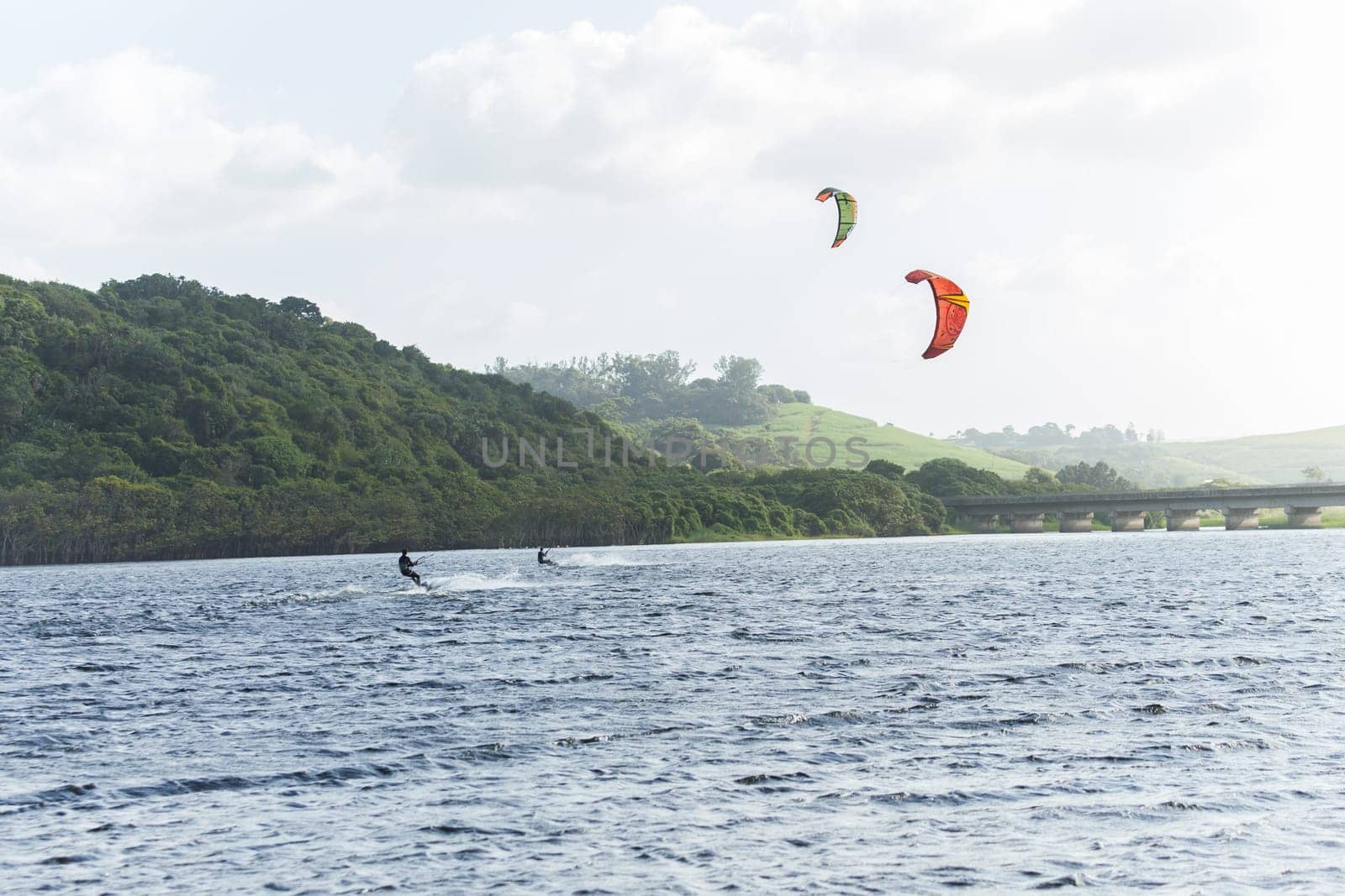 Kite surfing sport action in river lagoon waters and surf action Umdloti river lagoon north of Durban South Africa.