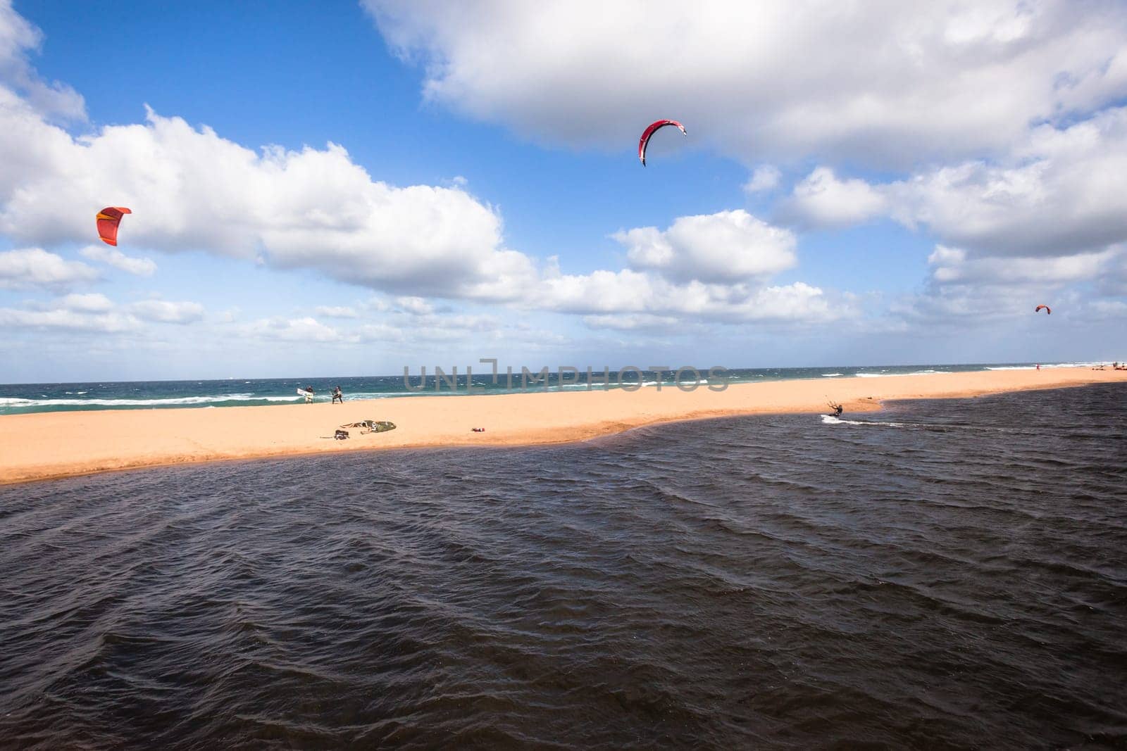 Kite surfing sport action in river lagoon waters and surf action Umdloti river lagoon north of Durban South Africa.