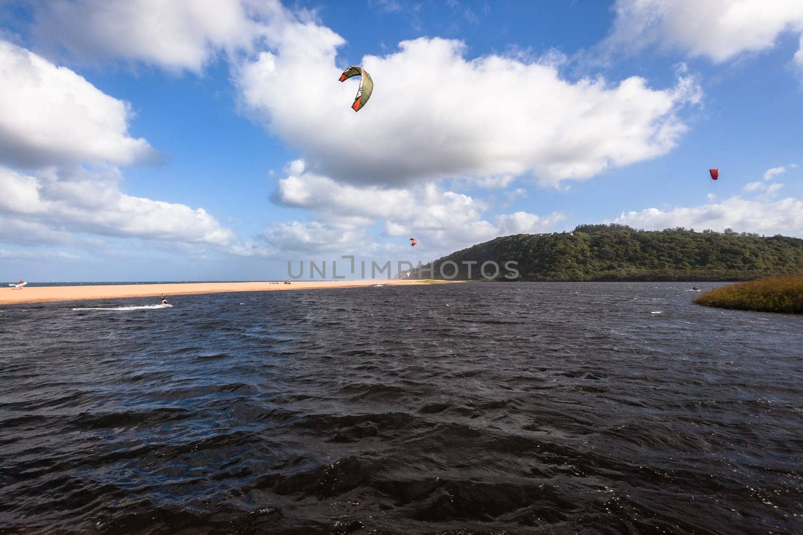 Kite surfing sport action in river lagoon waters and surf action Umdloti river lagoon north of Durban South Africa.
