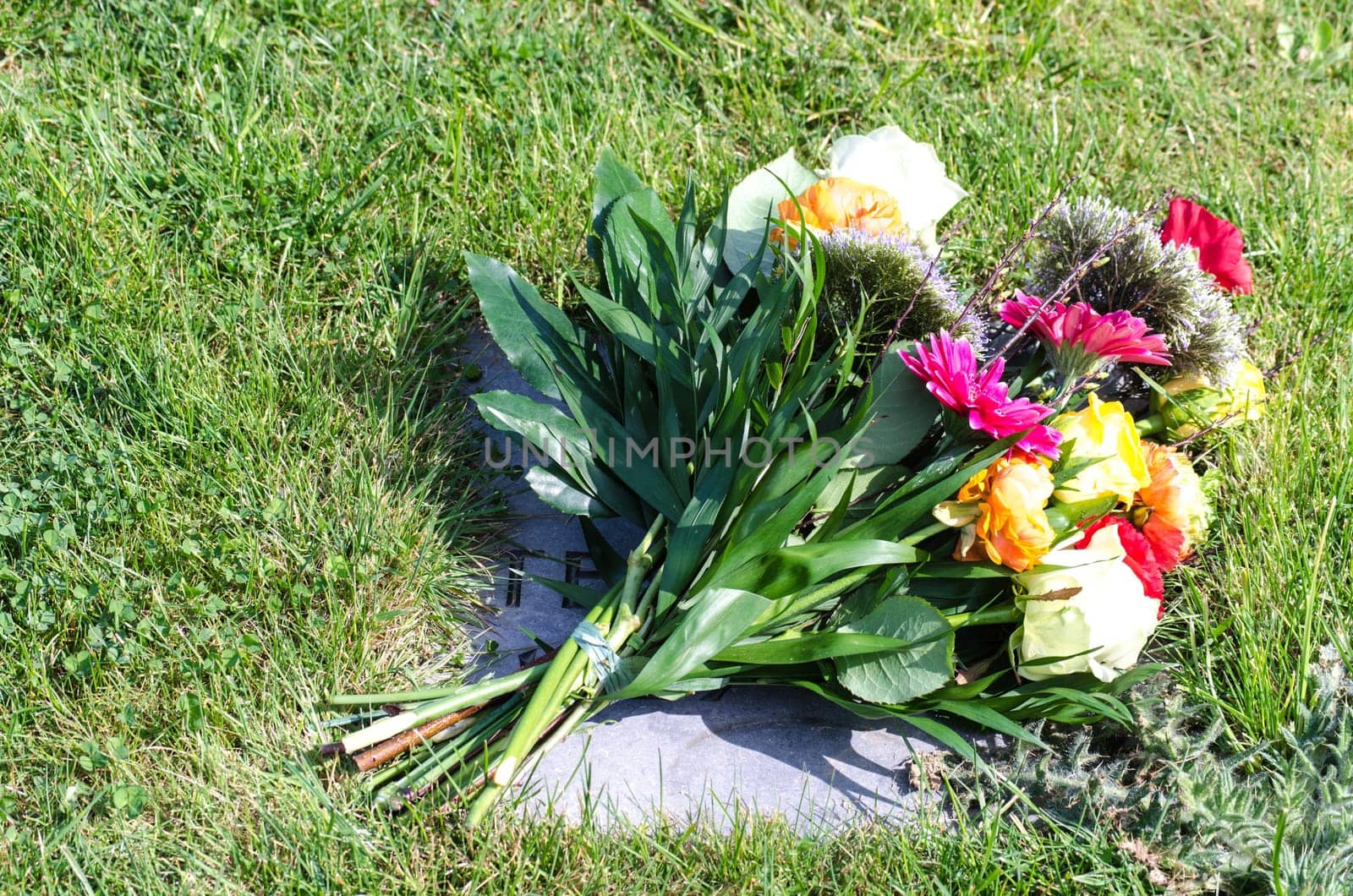 Schöner bunter Blumenstrauß auf einem Grabstein