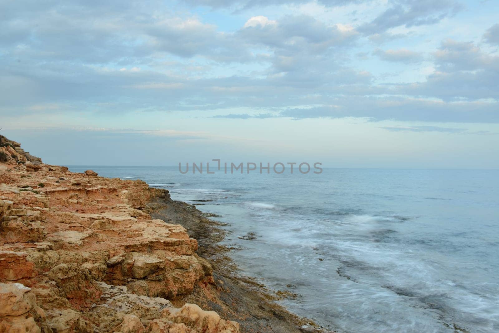 Rocky coast on sunset on a cloudy evening, Costa Blanca, Spain