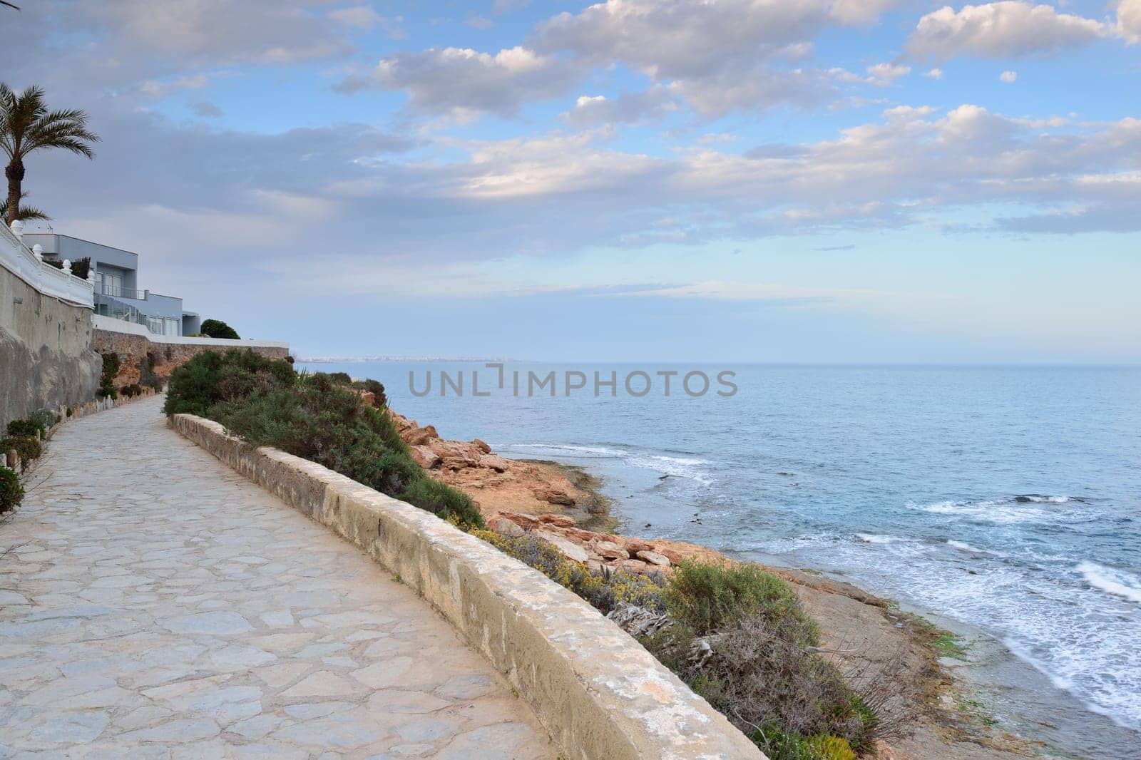 Paved coastal walkway on a summer evening, Cabo Roig, Spain