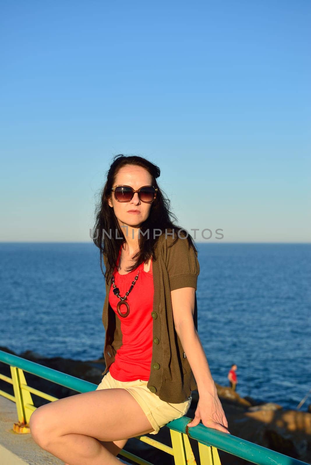 Young woman walking on the beach promenade on a beautiful summer evening, Costa Blanca, Spain