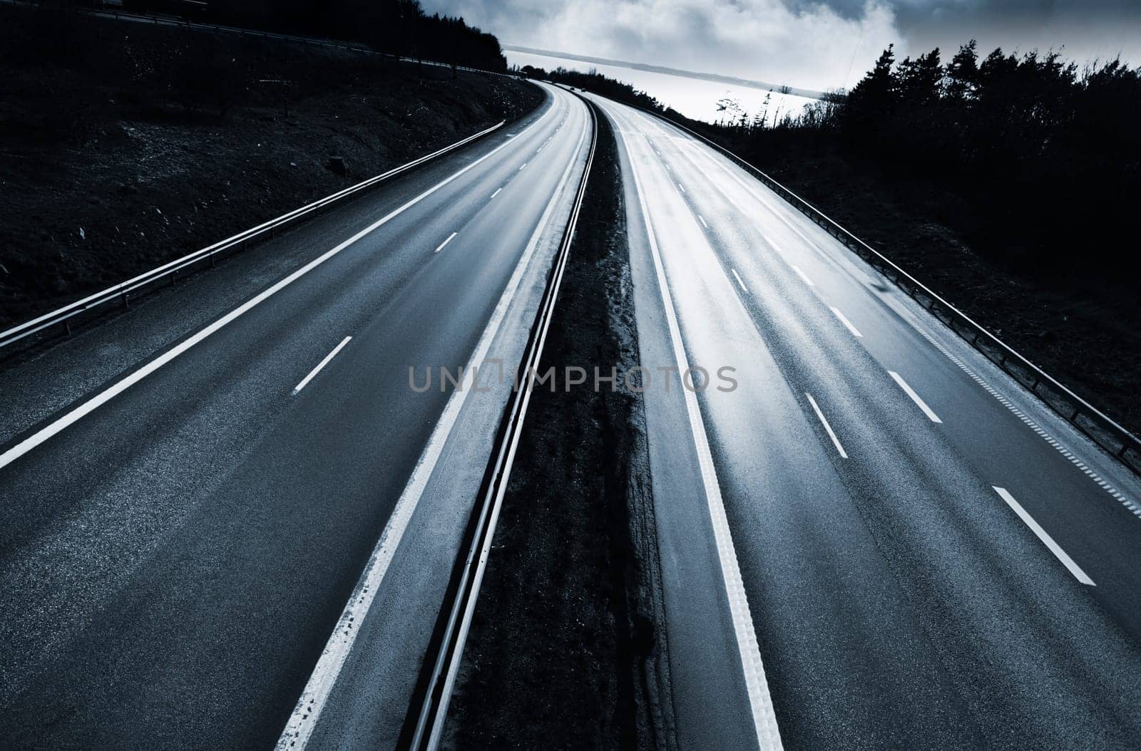 large dramatic highway, motorway at sunset, clouds, trees and forest