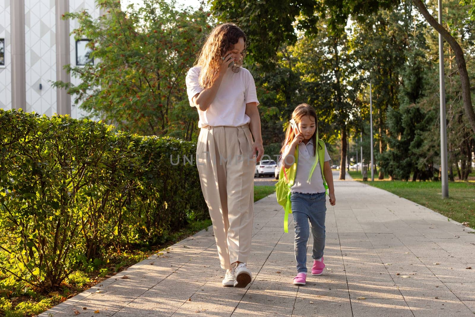 Mother and child walking on a sunny day in the park.