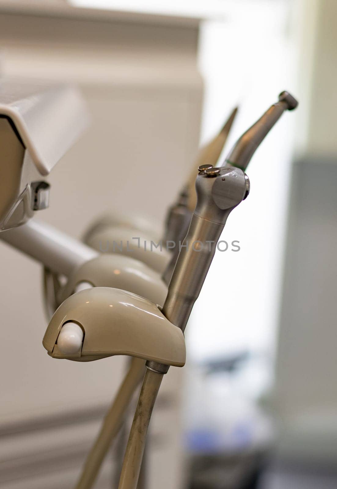 Dental oral drilling and rinsing instruments in the dentist's office in the hospital, close-up side view.