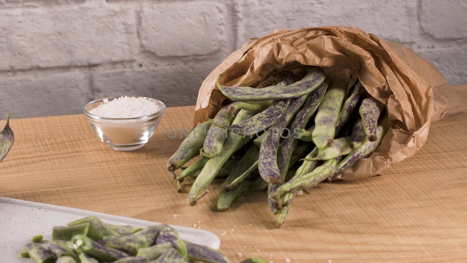 Heap of green beans on a rustic wooden table top view. Cutting board with green beans