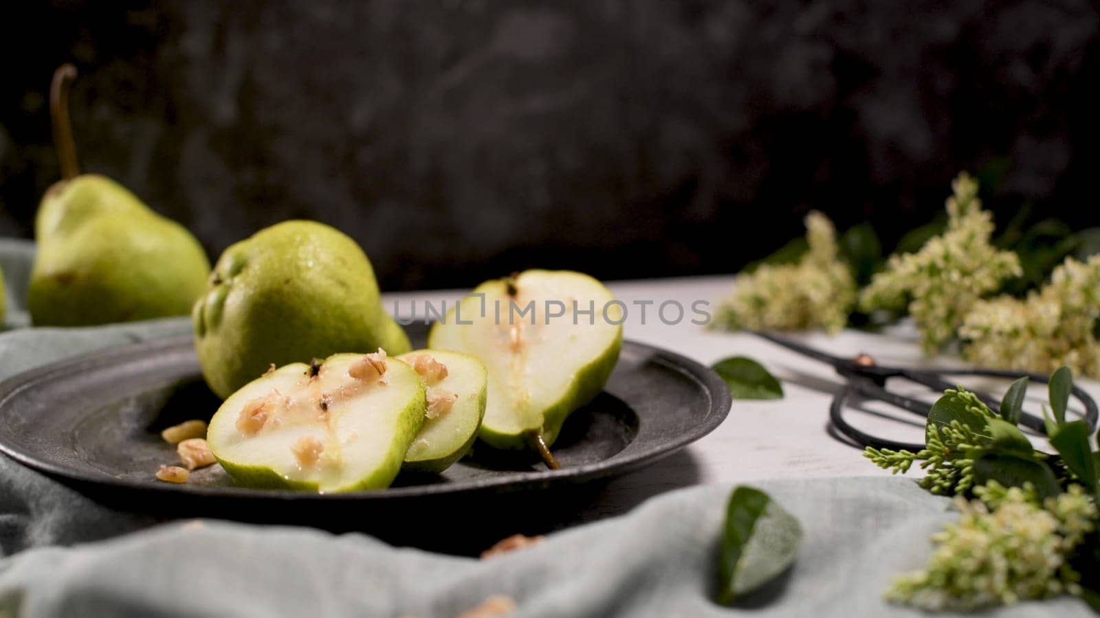 Metal plate with delicious ripe pears on table.