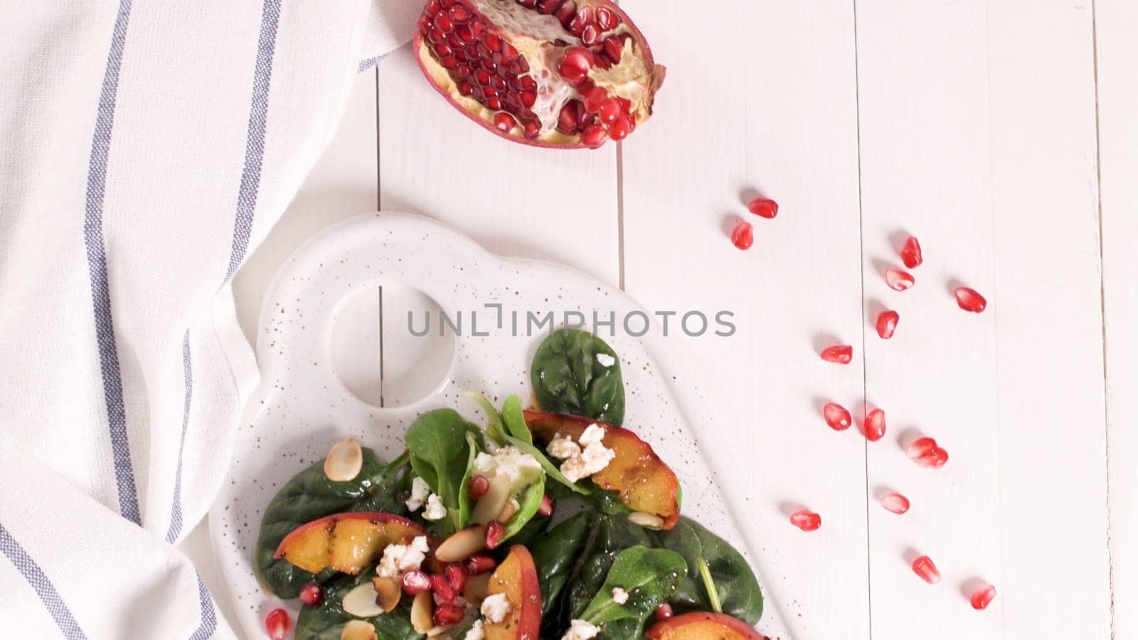 Fresh vegetable salad with grilled peach, pomegranate, spinach and fresh cheese.