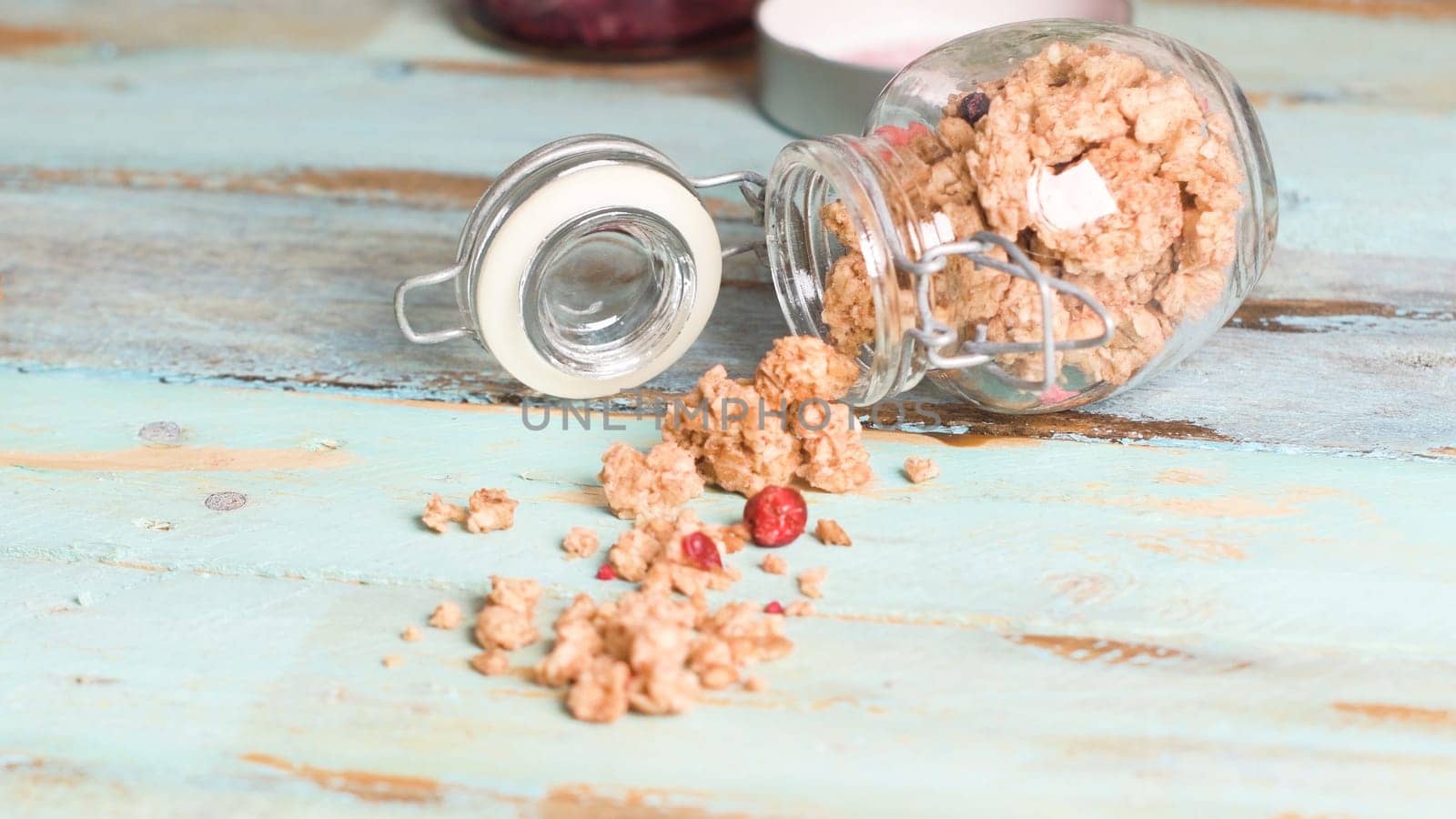 Glass jar with healthy breakfast cereal on wooden table.