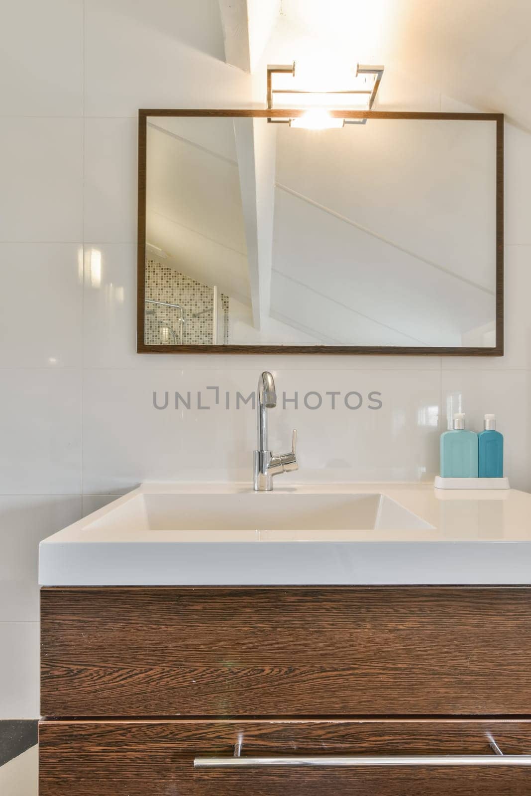 a bathroom with a mirror above the sink and vanity in front of it is white tiles on the wall behind