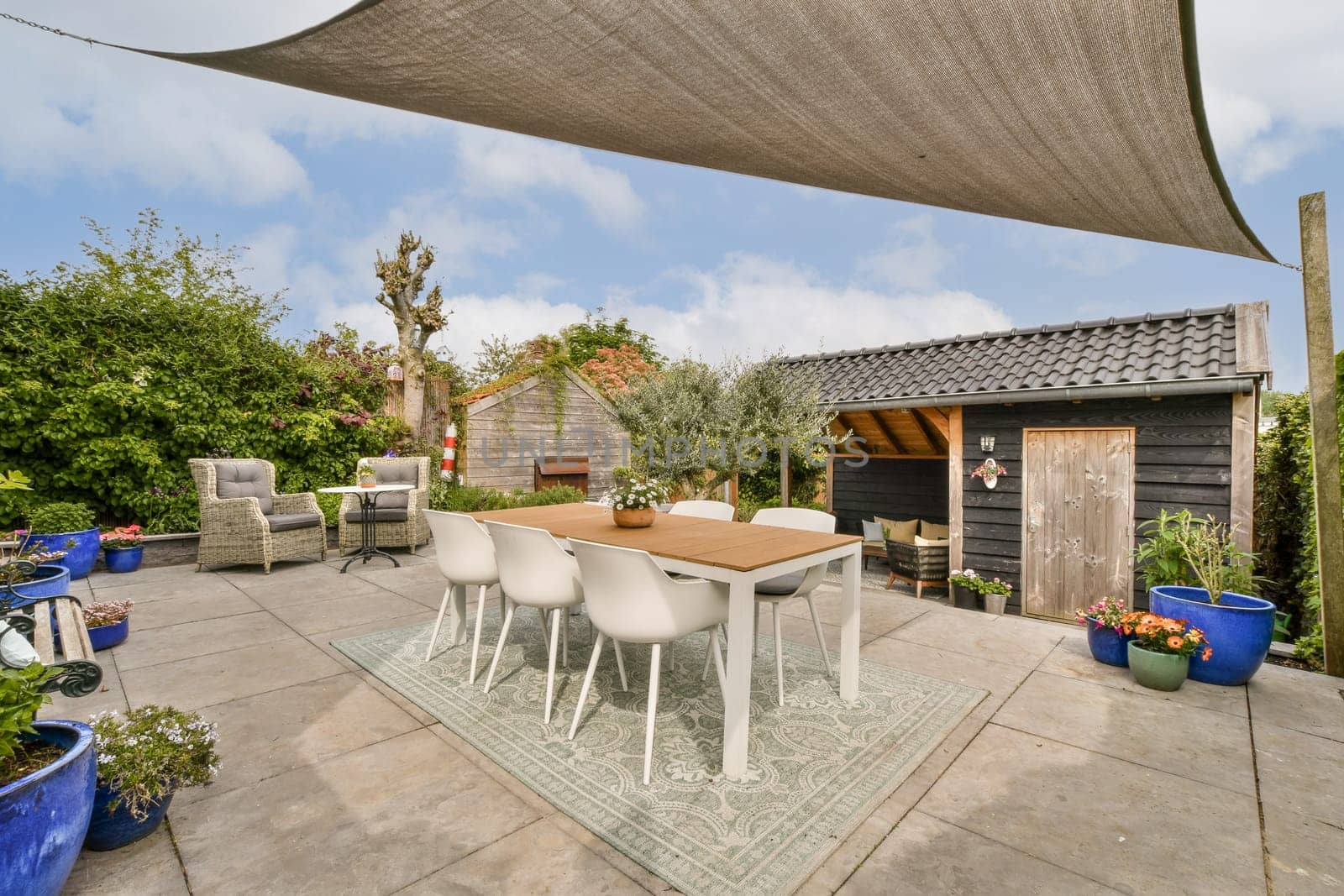 a patio with a table and chairs in a backyard by casamedia