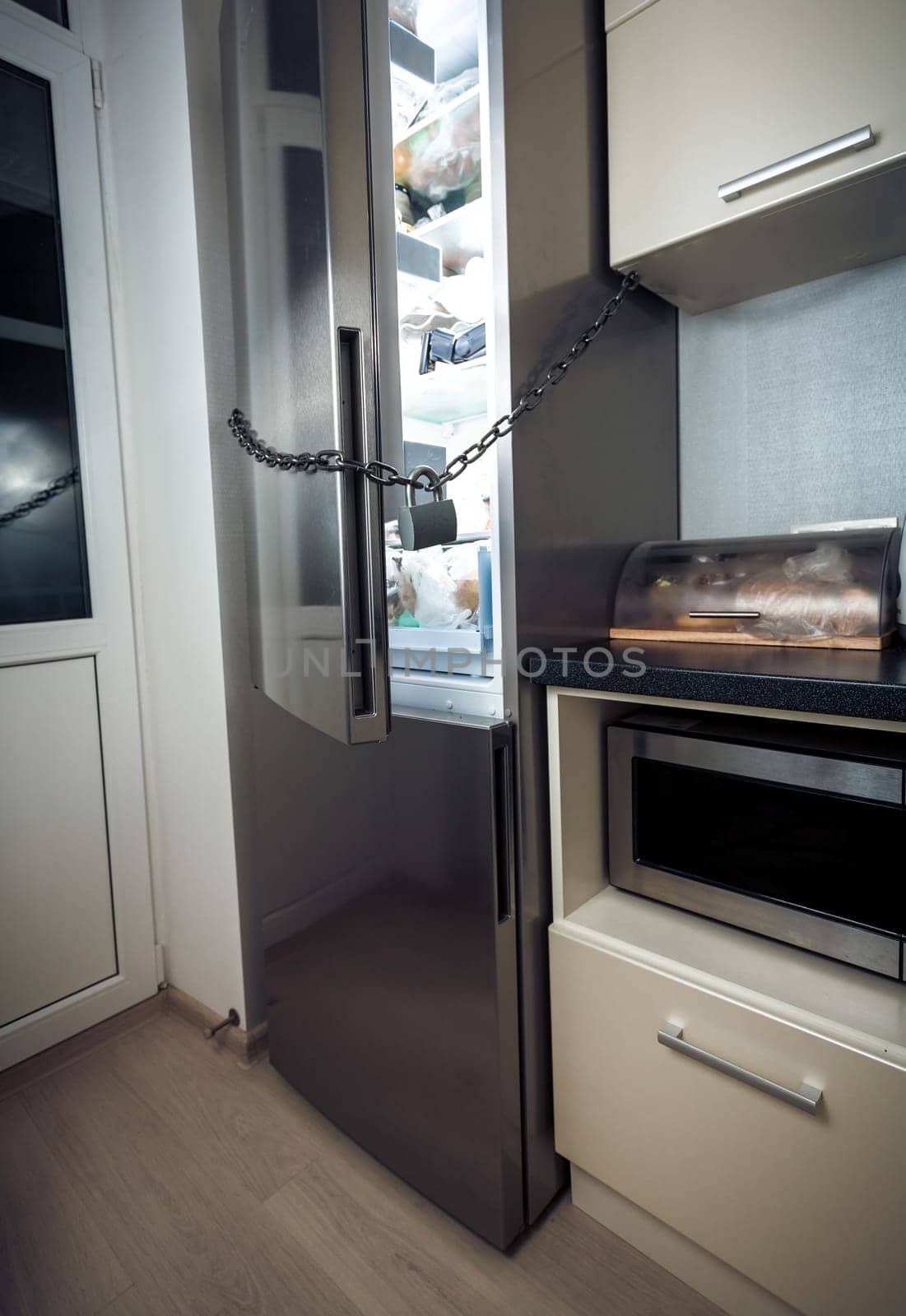 Photo of refrigerator on kitchen locked by chain