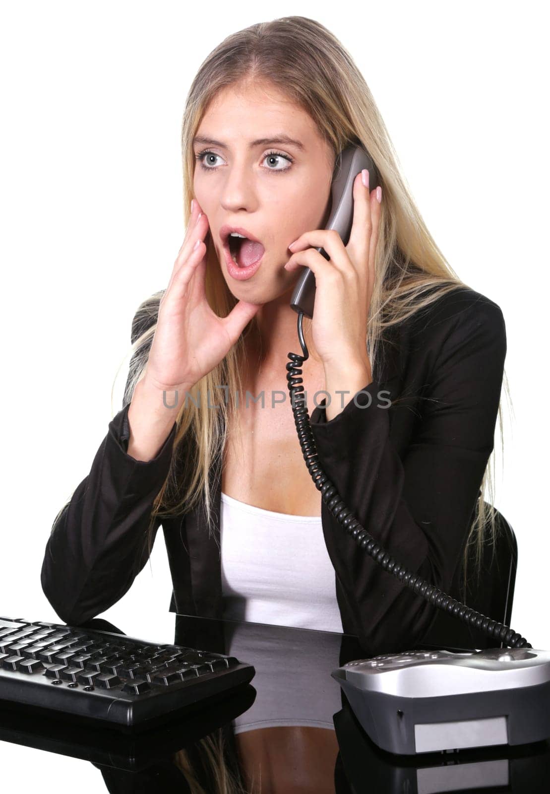 Pretty blond office secretary lady talkiing on telephone with shocked expression on her face