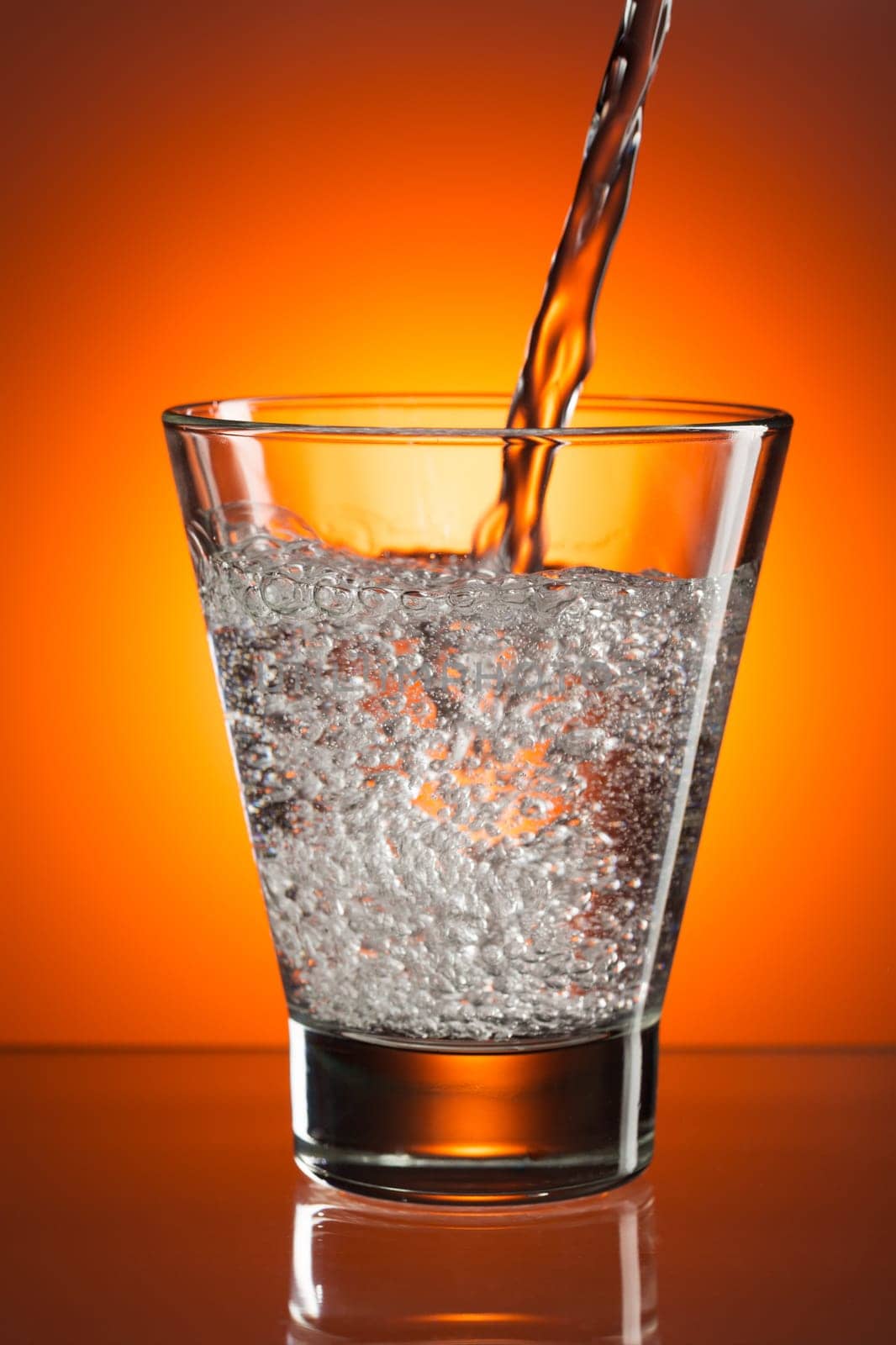 Glass of cognac in a distorted reflection.