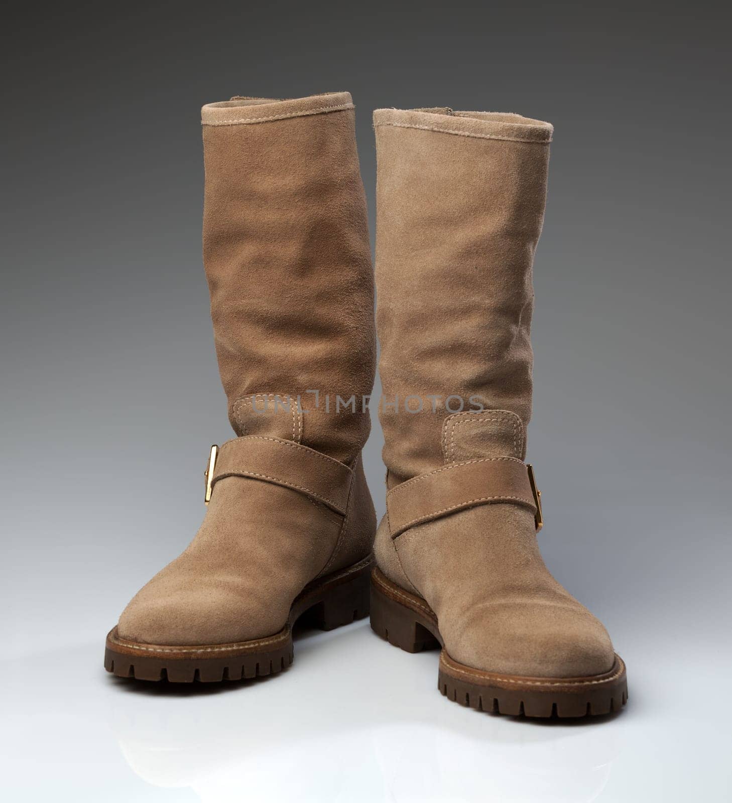 Pair of beige suede fashionable winter boots. Creative.