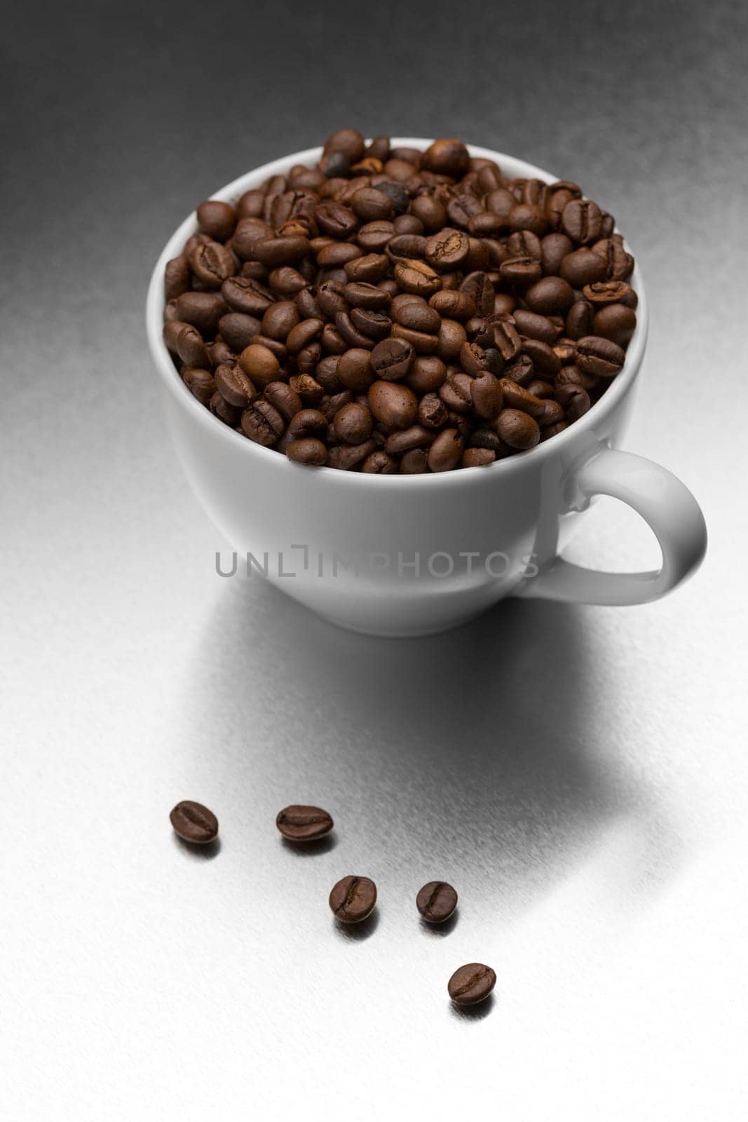 White coffee cup full of grain on textured steel surface