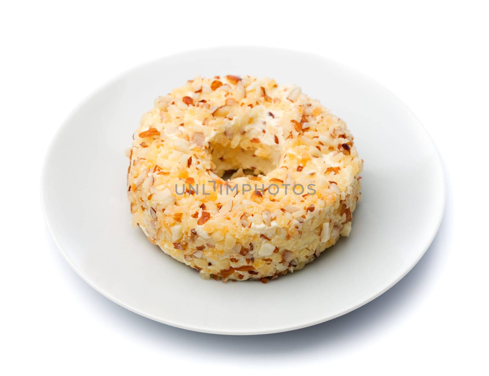Round sweet cheese with nuts and pineapple on a plate. Isolate on white.