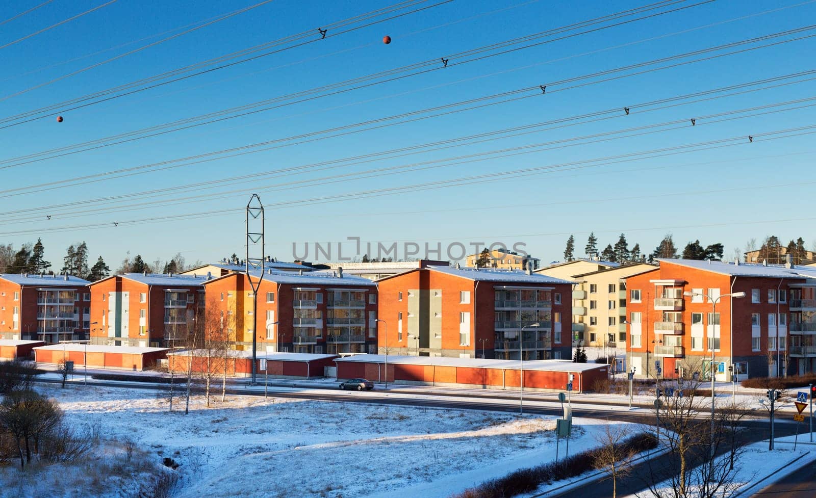 House on the outskirts of Helsinki, Finland. Winter, sunny day, blue sky without clouds, high-voltage wires.