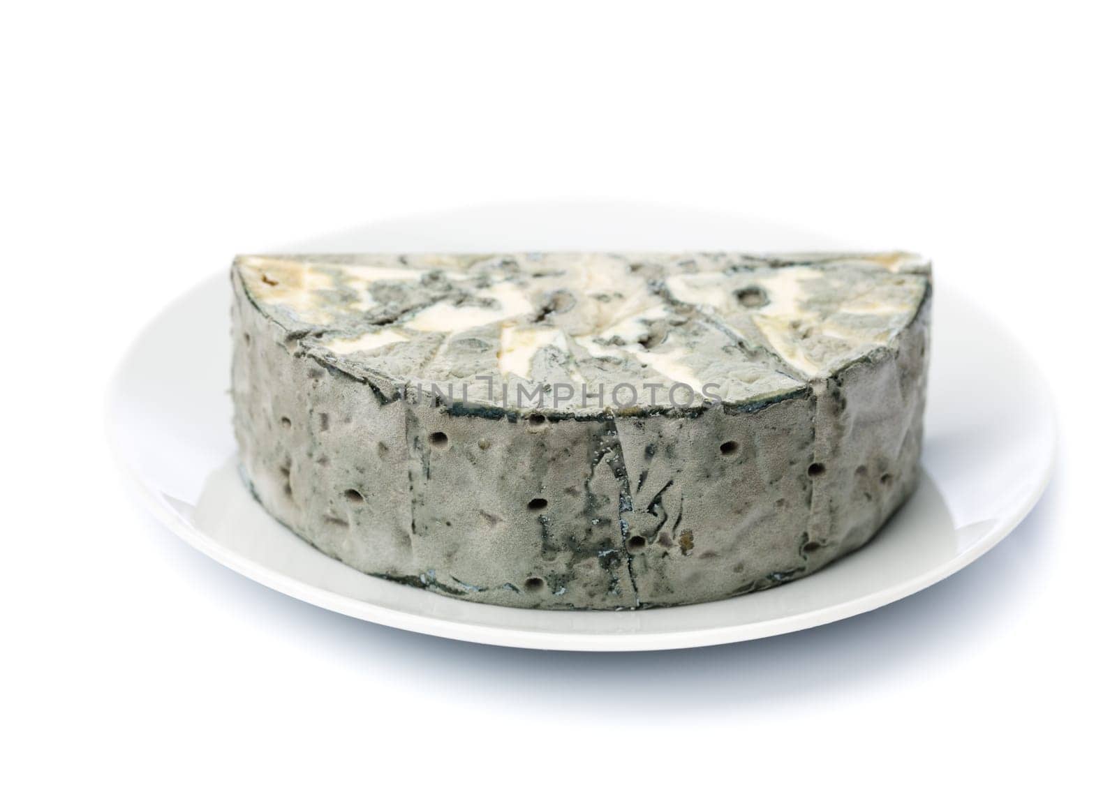 Cheese with black mold on the plate. Isolated on white background.